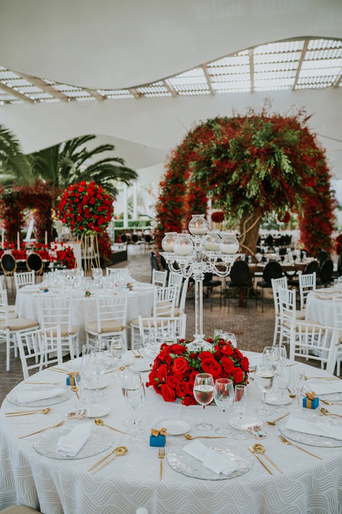 services-02 Elegant outdoor wedding reception with red roses and white tables, creating a luxurious ambiance.