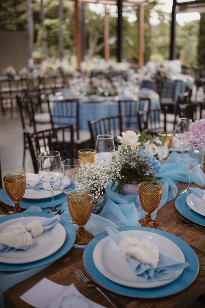 about-01 Beautifully decorated outdoor wedding reception table with blue theme and floral centerpiece.